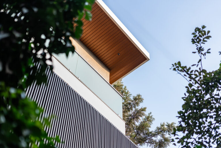 A wide-angle view of a modern luxury residence in India featuring clean lines, large glass windows, and a sophisticated architectural profile.
